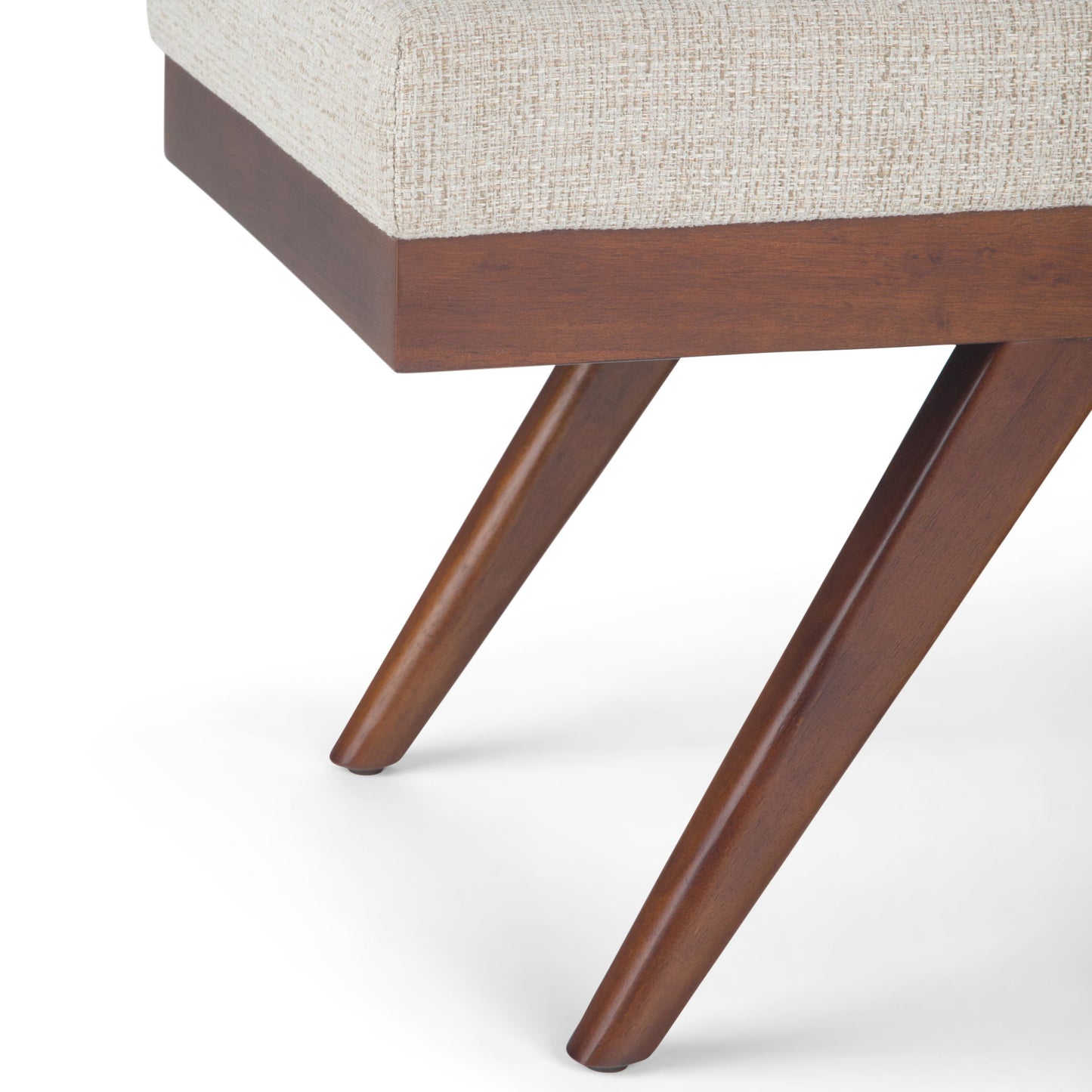 Close-up of the Chanelle - Mid-Century Ottoman Bench featuring angled wooden legs and a light beige upholstered seat, set against a white background.