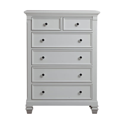 The Glendale 6 Drawer Chest is a tall, light gray wooden dresser with six drawers, black round knobs, decorative trim, and short carved legs.