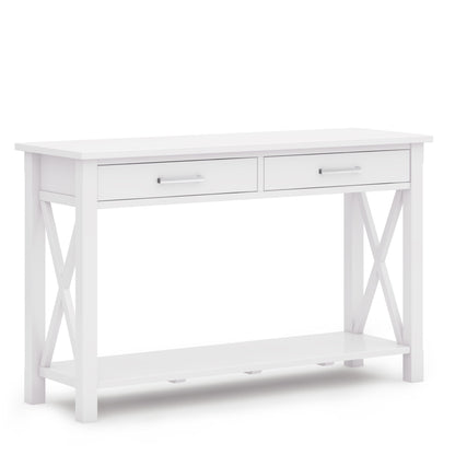 The Kitchener - Handcrafted Table is a white wooden console table featuring two drawers with silver handles, X-shaped side supports, and a lower shelf, displayed against a white background.