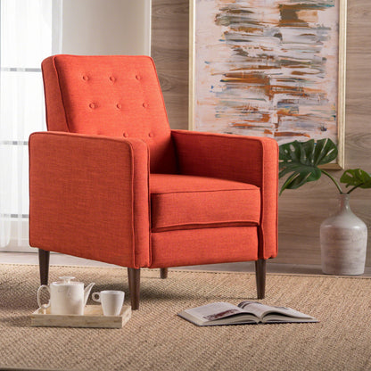 A Mid-Century Modern Recliner With Button Tufted Waffle Stitch in orange sits on a woven rug beside a wooden tray with teacups and an open book, set against a large plant and abstract art painting in the background.