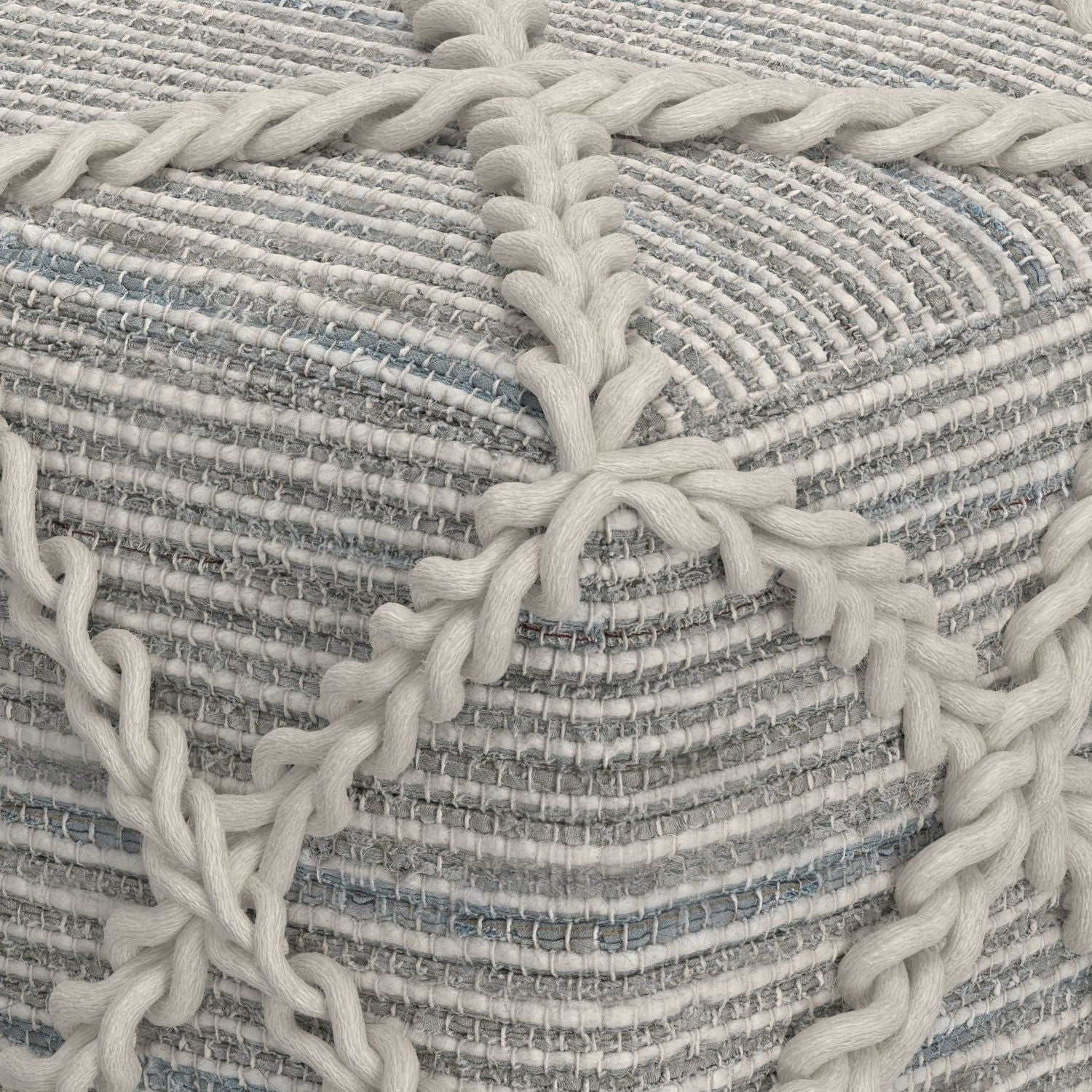 Close-up of the Cowan Handcrafted Square Pouf featuring thick, cream yarn braided over a textured, striped fabric in gray, white, and light blue tones.