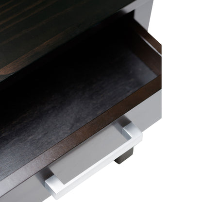 A close-up of an empty, partially open drawer with a metallic handle on the dark wood Kitchener - Handcrafted Table.