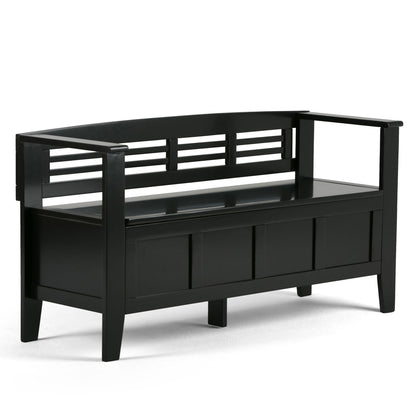 The Adams - Entryway Storage Bench Handcrafted is a modern black wooden bench with armrests, a slatted backrest, and a storage compartment beneath the seat, shown against a white background.