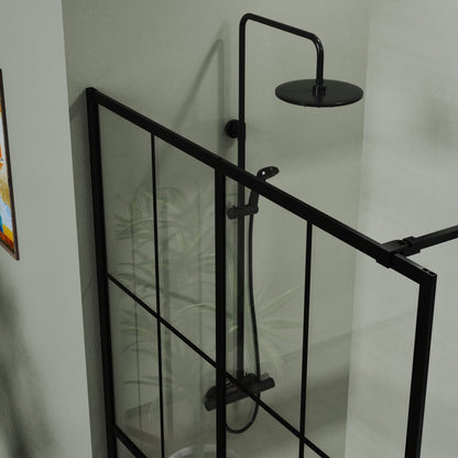 A top view of the Shower Screen Walk In Wet Room - Black shows sleek black-framed glass panels and a matching rainfall showerhead, with a plant just outside the enclosure and part of a picture visible on the wall.