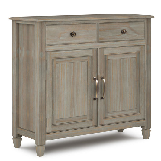 The Connaught Entryway Storage Cabinet in distressed gray features two top drawers with round knobs, two paneled doors with curved handles below, and stands on short tapered legs for a stylish storage solution.