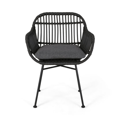 The Outdoor Rattan Accent Chair With Metal Legs features a modern black rattan frame, curved back, open slatted design, metal legs, and a dark gray seat cushion, displayed from the front on a white background.