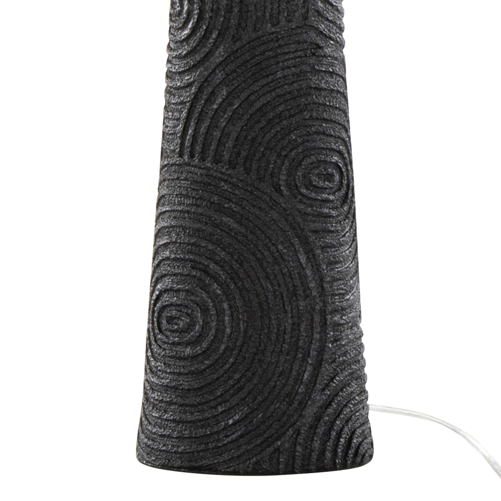 Close-up of the Kona - Contemporary Table Lamp (Set of 2) in Matte Black, showing its textured base with concentric circles and a white power cord extending from the right.