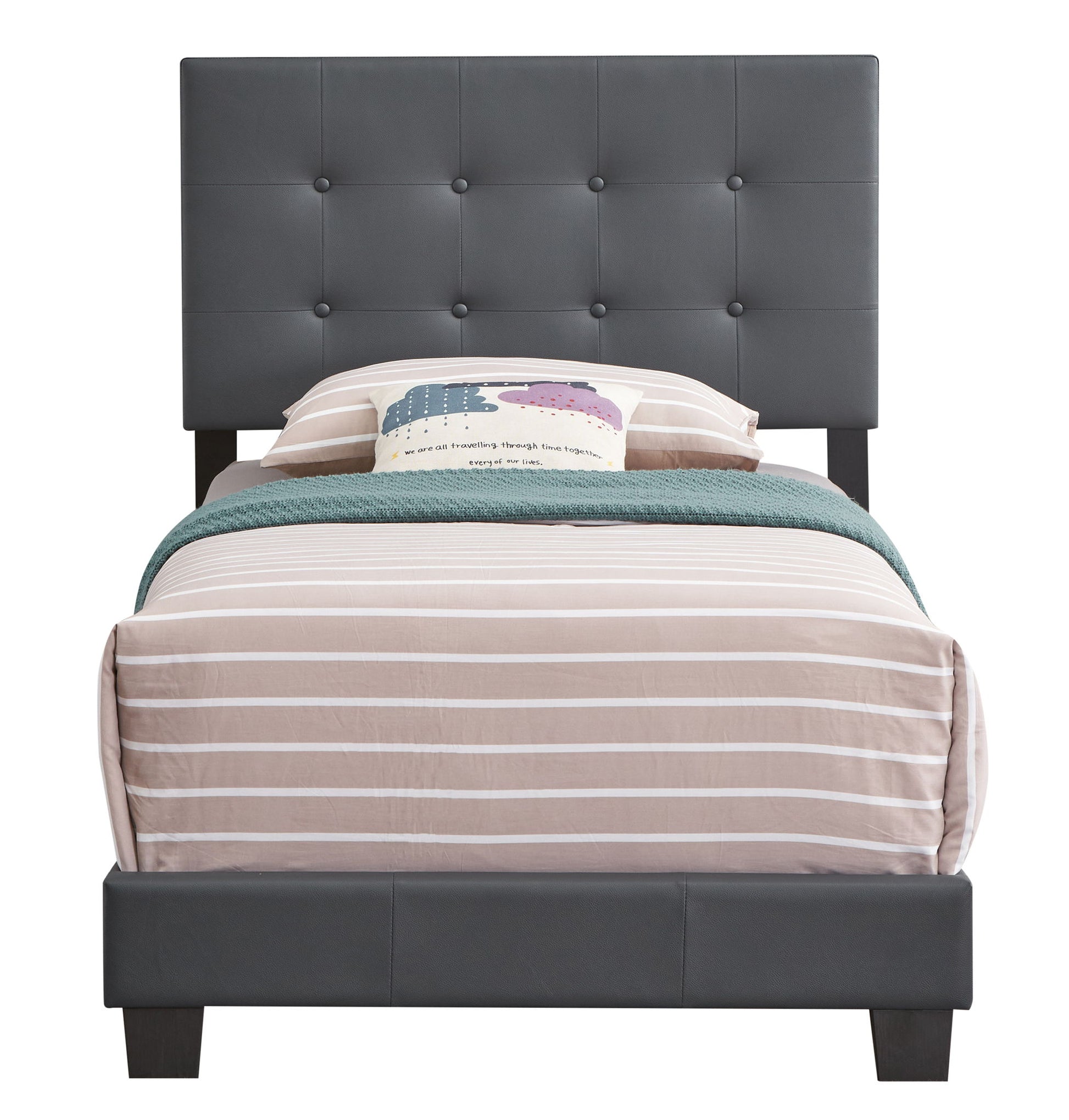 The Caldwell - Bed features a twin size with a tall dark gray tufted headboard, beige and white striped bedding, a green throw blanket, and a decorative pillow with colorful clouds and text.