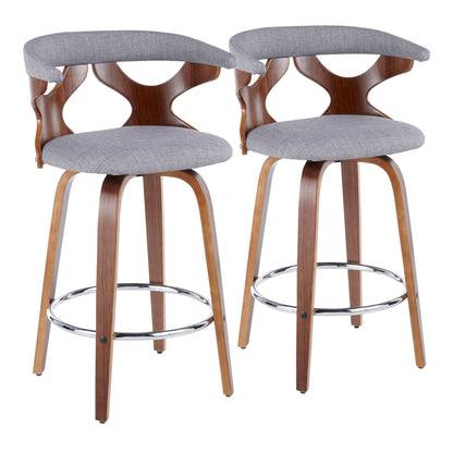 The Gardenia Mid Century Modern Counter Stool set includes two stools with curved wooden backs, open geometric designs, gray cushioned seats, wooden legs, and stylish chrome footrests, arranged side by side.
