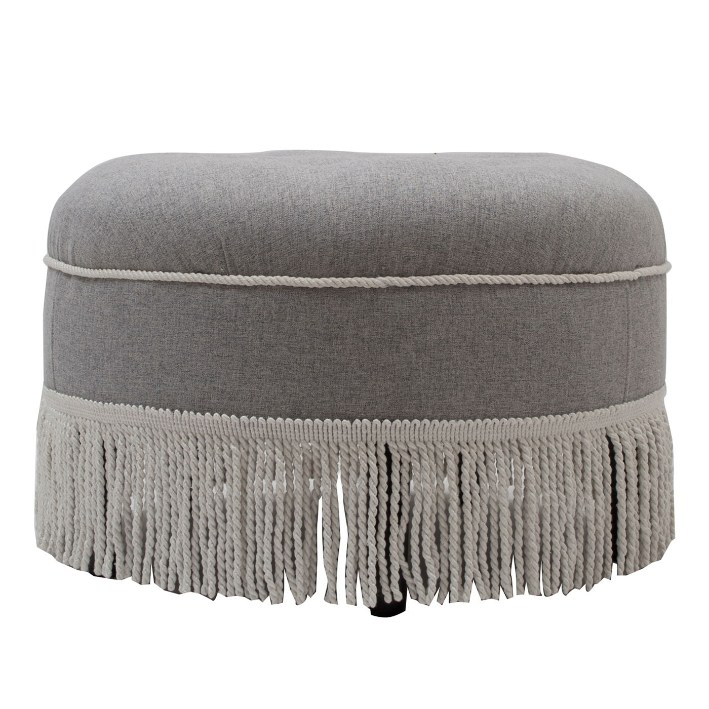 The Yolanda Round Upholstered Accent Ottoman features a light gray fabric, decorative fringe along the bottom edge, and subtle cord detailing near the top.