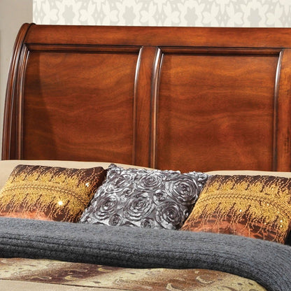 The LaVita - Storage Bed features a wooden sleigh headboard with a glossy finish, three decorative pillows—two in gold and brown patterns and one with a gray floral design—and a folded gray blanket at the foot of the bed.
