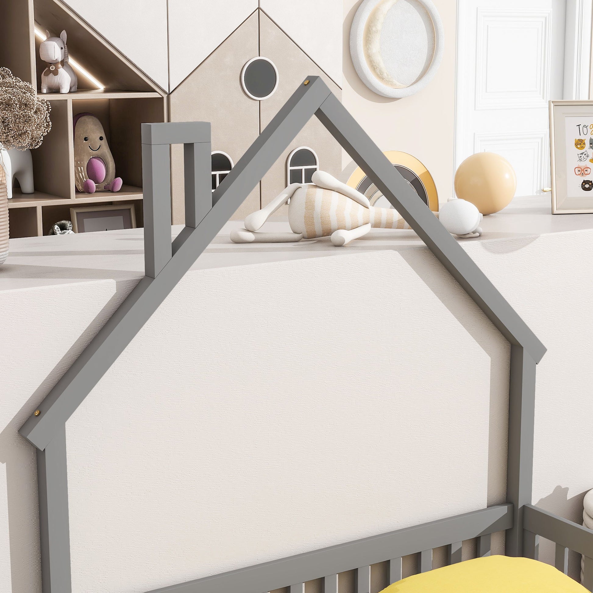 A cozy kids' room featuring the House-Shaped Headboard Floor Bed With Fence in gray, plush toys on shelves, a round mirror, decorative balls, and pastel colors for a playful, inviting vibe.