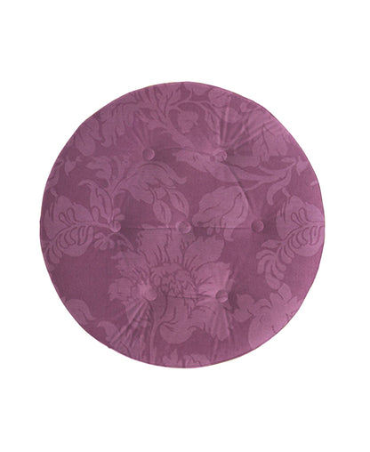 The Yolanda Luxurious Upholstery Round Upholstered Accent Ottoman features a subtle floral damask pattern in dusty rose or mauve, finished with six fabric-covered buttons for an elegant touch.