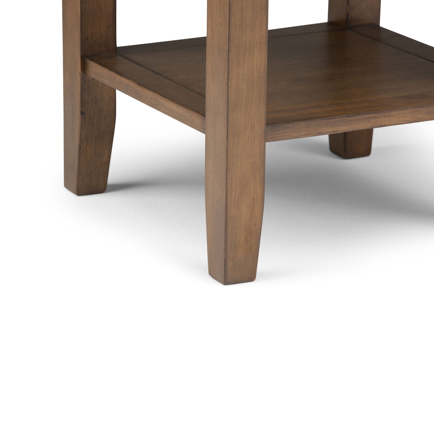 Close-up of the Redmond - Handcrafted End Table, featuring four legs and a lower shelf in a natural wood finish. The table stands on a plain white surface.