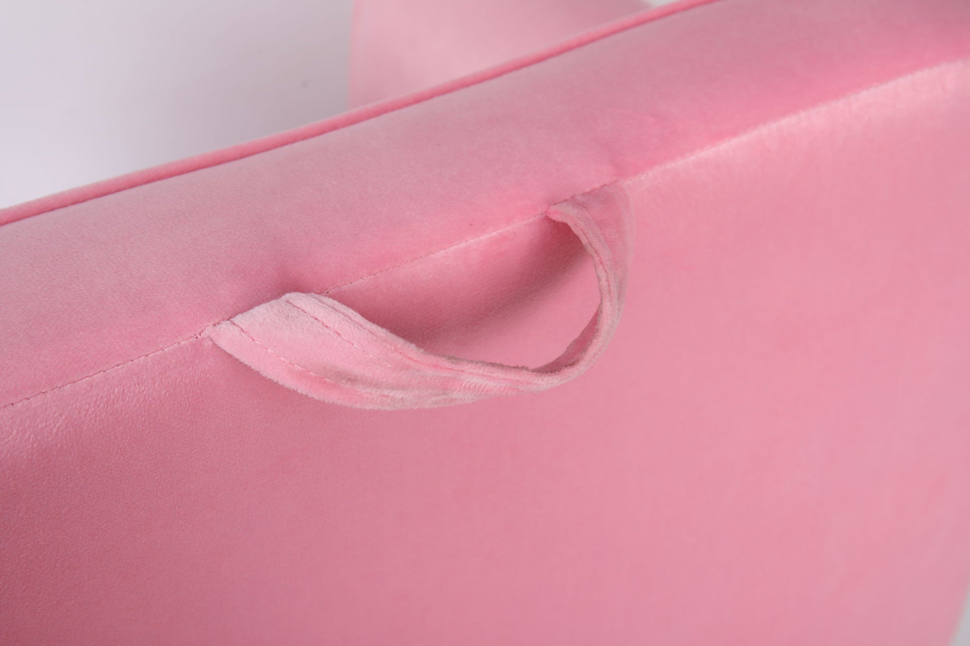 Close-up of a soft, light pink fabric handle sewn onto the Durable Design Kids Club Sofa, featuring a matching pink color, smooth texture, and gentle lighting.