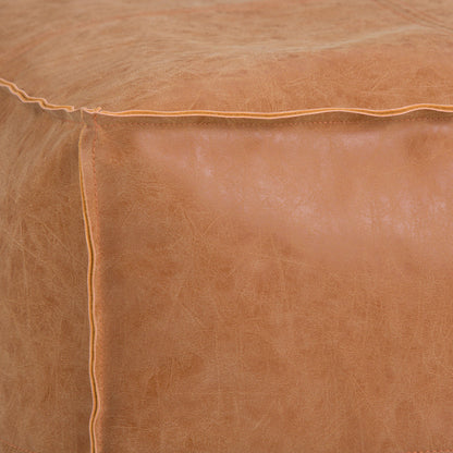 Close-up of the Brody - Versatile Square Pouf in light brown leather, featuring visible edge stitching and a slightly worn, textured surface.