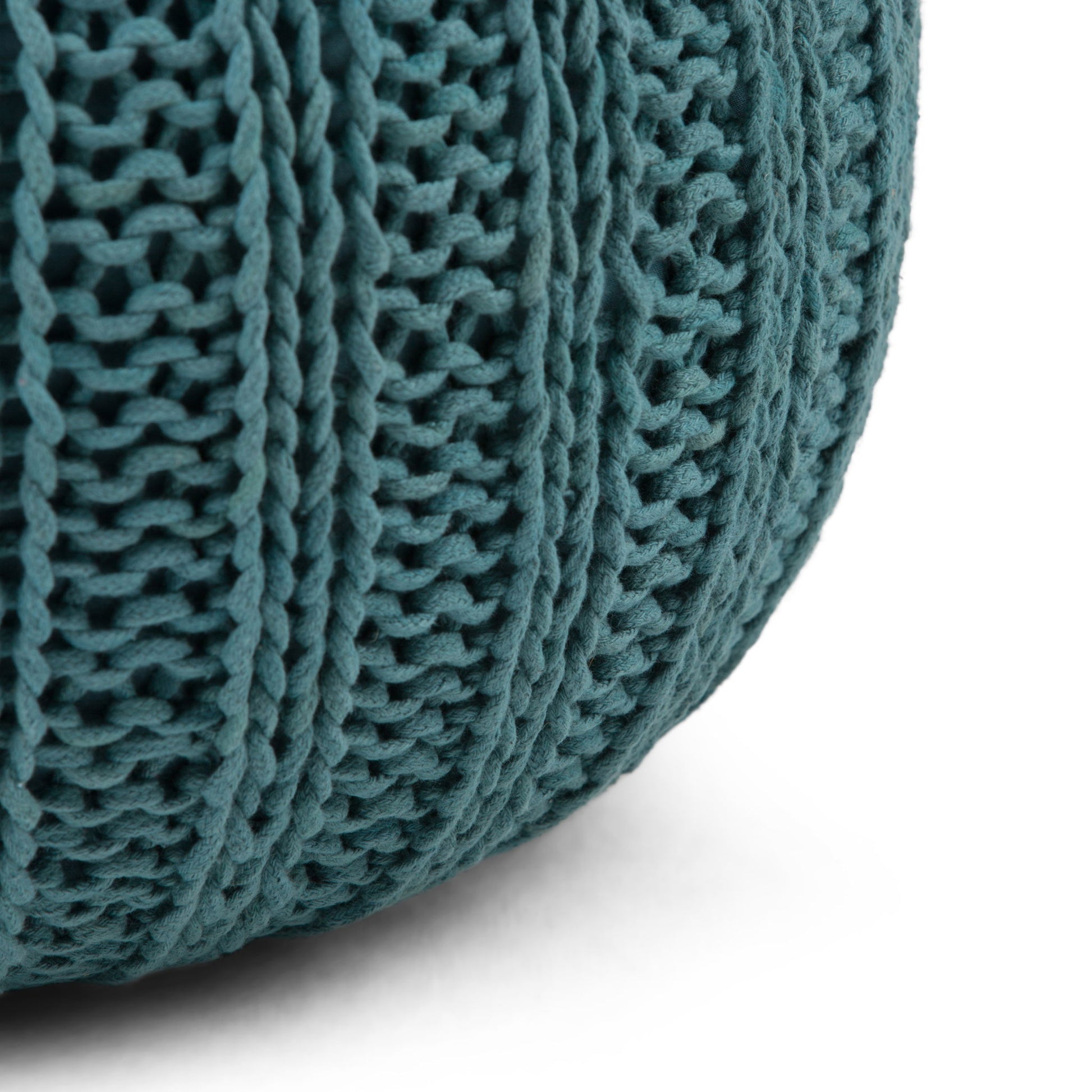 Close-up of the Shelby - Handcrafted Hand Knit Round Pouf in teal, featuring a ribbed, textured pattern against a white background.