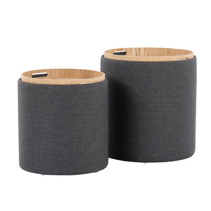 The Tray - Contemporary Nesting Ottoman Set includes two round, grey fabric ottomans with light wooden removable lids featuring small handle cutouts; one ottoman is slightly taller than the other.