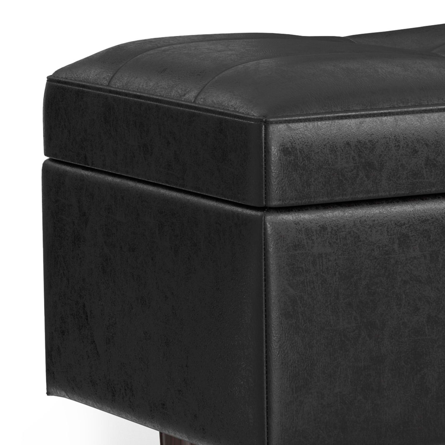 Close-up of the Shay Large Square Coffee Table Storage Ottoman in black faux leather, featuring visible stitching on the cushioned top and textured sides. Shown angled to highlight its sleek, mid-century modern design.