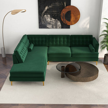 A modern living room featuring the Christian Mid-Century Modern Design Sectional Sofa in green, a round glass and wood coffee table, tall floor lamp, abstract wall art, and a potted plant on a white rug over patterned wood flooring.