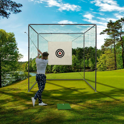 A person swings at a Golf Practice Net Cage With Metal Frame Hitting Net Kit Indoor Outdoor - Black, aiming for concentric targets inside the cage on a green course surrounded by trees beneath a partly cloudy sky.