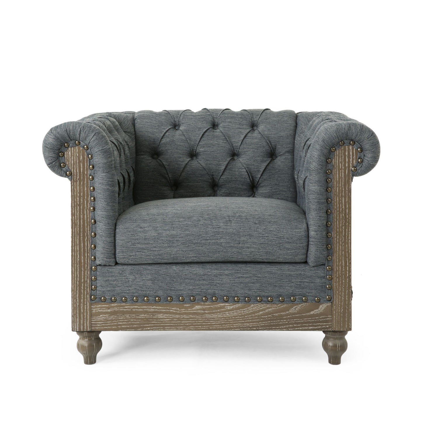 The Fabric Upholstered Club Chair With Scrolled Tuxedo Arms features a gray tufted design, rolled arms, wooden legs, brass nailhead trim, and textured fabric in a classic Chesterfield style, shown against a white background.