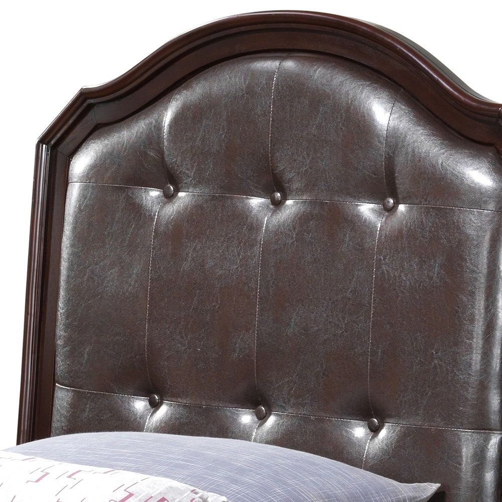 A close-up of the Triton - G9000A-TB Twin Bed's tufted, dark brown leather headboard with a curved top and six-button pattern in cappuccino color. A pillow with a patterned case is partially visible at the bottom edge.