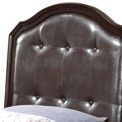 A close-up of the Triton - G9000A-TB Twin Bed's tufted, dark brown leather headboard with a curved top and six-button pattern in cappuccino color. A pillow with a patterned case is partially visible at the bottom edge.