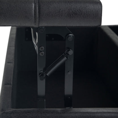 Close-up of the Harrison - Upholstered Coffee Table Storage Ottoman in black, with the lid partially open to reveal the metal hinge and spring mechanism. Both interior and exterior are upholstered in matching black material.