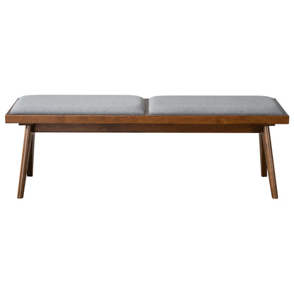 The Keira - Modern Aesthetics Bench features a sleek wooden frame with angled legs and two rectangular grey upholstered seat cushions.