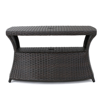 The Berkeley - Chaise Lounge Side Table features a dark brown wicker design with a flat top, open middle shelf, and slightly curved base, ideal for storage or use as a stylish outdoor side table.