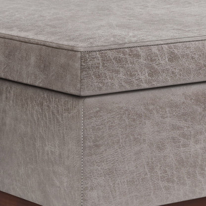 Close-up of the corner of the Owen - Lift Top Large Coffee Table Storage Ottoman, Mid Century Style, featuring gray upholstery with visible stitching and a textured, slightly distressed fabric finish.