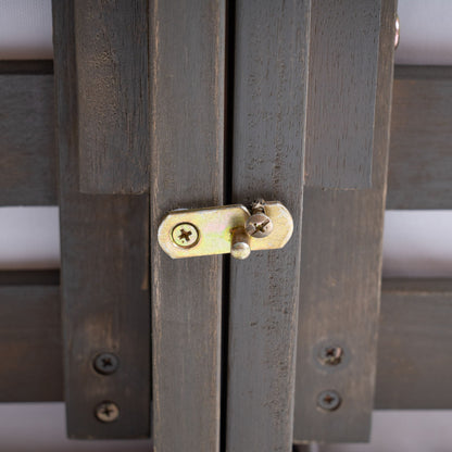 Close-up of the Oana - Arm Chair showing a brass locking latch secured with screws across two dark wood panels, highlighting visible grain and subtle signs of wear.