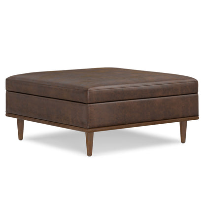 The Shiloh Multifunctional Square Storage Ottoman features brown leather upholstery, a cushioned top, and four tapered wooden legs, shown against a white background.