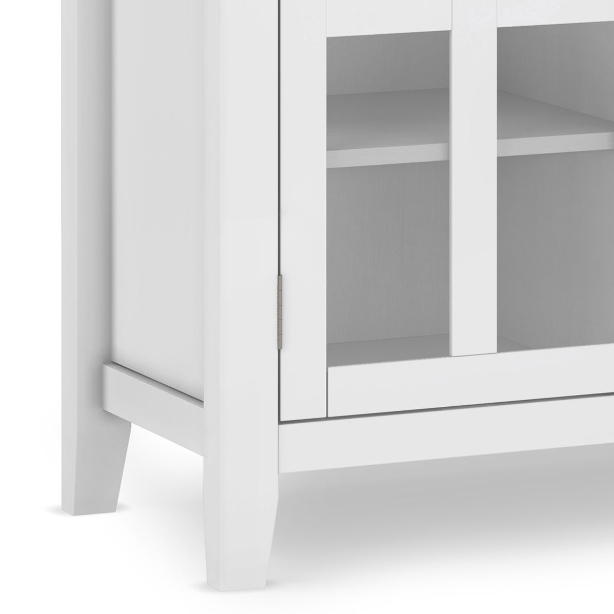 Close-up of the bottom corner of the Artisan - Handcrafted, Tall TV Media Stand in white, featuring a glass door and an interior shelf visible through the glass.