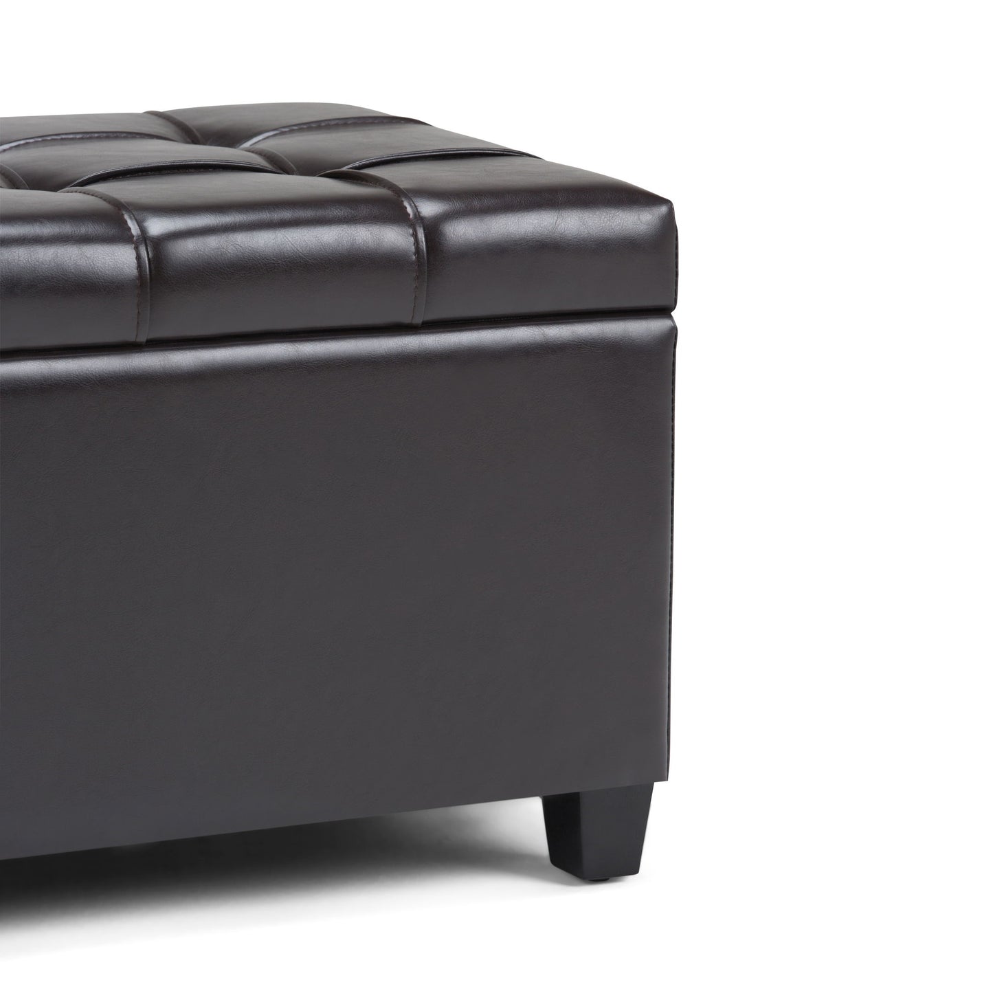 Close-up of the Sienna Upholstered Storage Ottoman Bench in dark brown faux leather with tufted detailing and short black legs, shown on a white background.