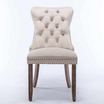 The Nikki set features two modern, high-end dining chairs with tufted velvet upholstery, solid wood legs, and nailhead trim, shown against a plain white background.