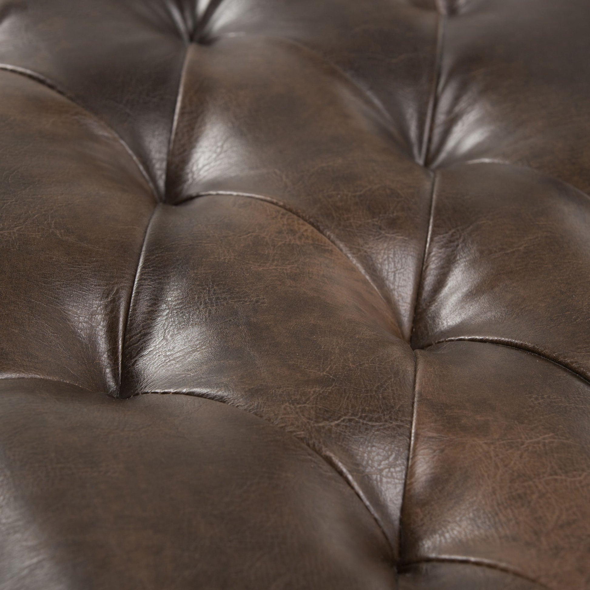 Close-up of the Henley Tufted Ottoman Bench in distressed brown, highlighting button details, natural leather texture, visible creases, and a rich sheen.