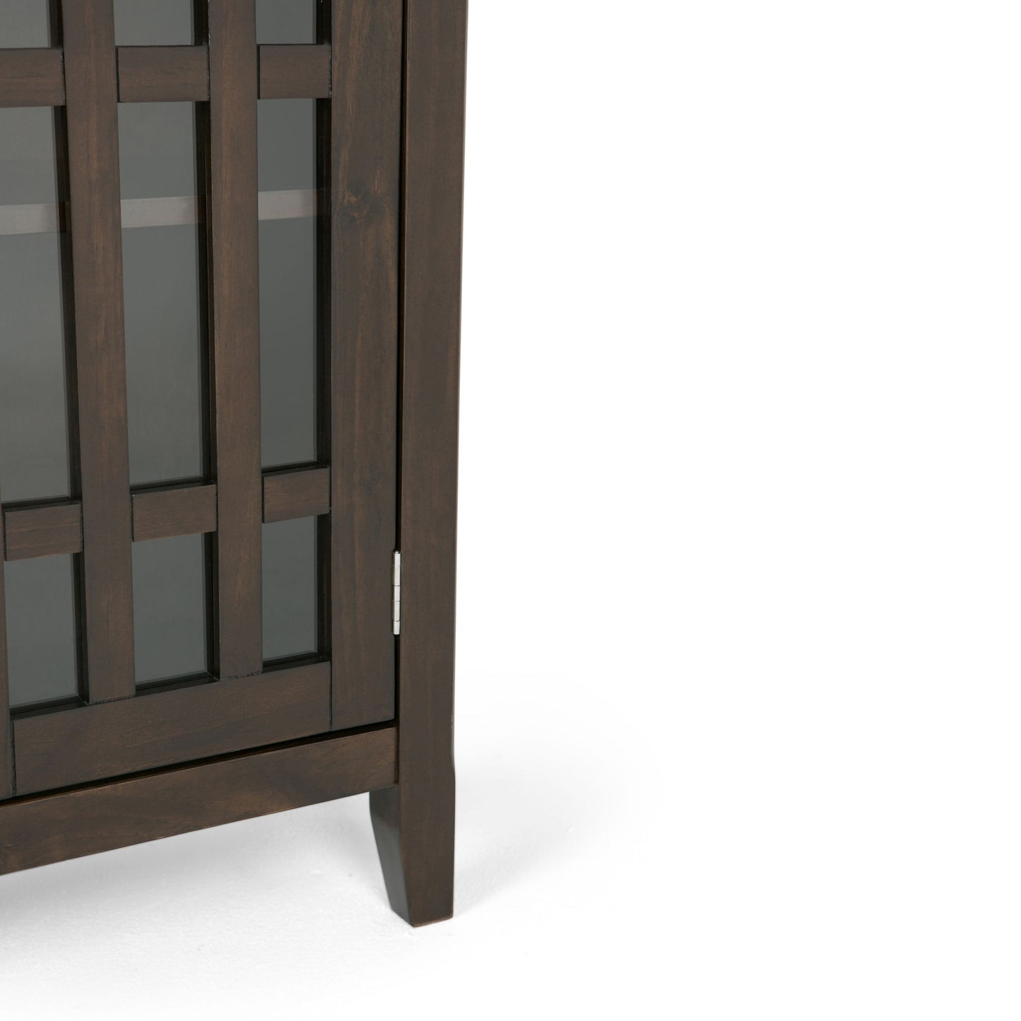 A close-up of the Bedford - Storage Media Cabinet, made of dark wood with a grid-design glass door, standing on four legs against a plain white background.