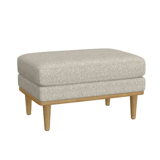 The Revel Chair Ottoman in tan features a rectangular cushioned top, light beige upholstery, wooden legs, and a simple modern design.