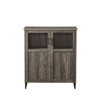 The Modern Grooved Door Accent Cabinet features two doors with rectangular glass panels on top, vertical wood paneling below, a weathered gray finish, metal handles, and short legs.