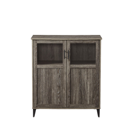 The Modern Grooved Door Accent Cabinet features two doors with rectangular glass panels on top, vertical wood paneling below, a weathered gray finish, metal handles, and short legs.