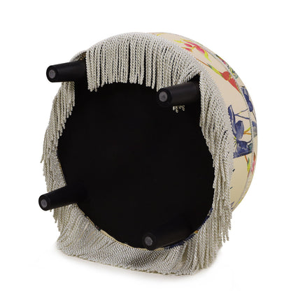 The Yolanda Round Upholstered Accent Ottoman features a floral pattern, four black legs, and decorative silver fringe around the edge. It is shown upside down.