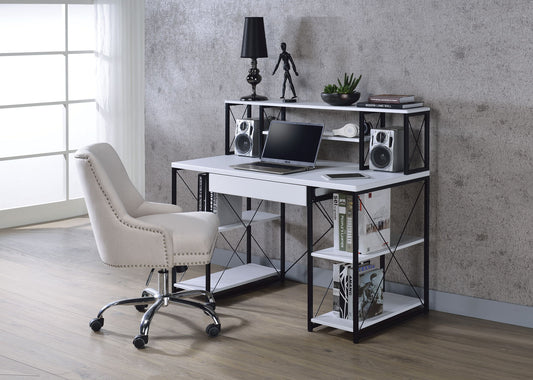 A modern home office with the Amiel All Purpose Writing Desk, featuring shelves holding a laptop, speakers, books, plants, and a mannequin figurine. A cushioned swivel chair is placed in front by a large window.