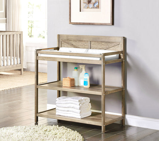 The Barnside - Changing Table Vintage features a padded changing mat, shelves with towels, wipes, bottles, and baby care items, all set in a sunlit nursery room.
