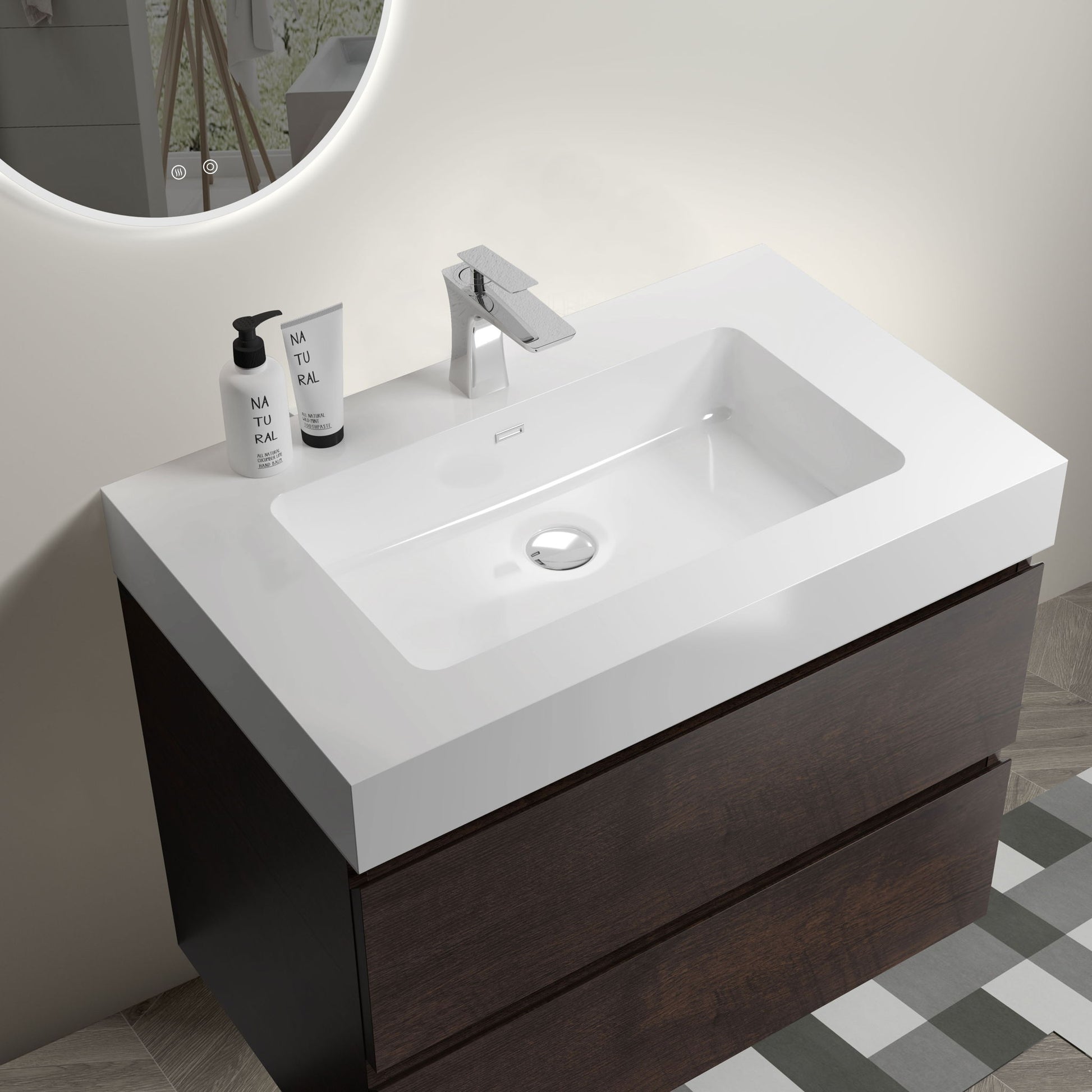 The Alice wall-mounted bathroom vanity features a large storage cabinet with a one-piece rectangular sink basin (no drain or faucet included), complemented by a round mirror on a light wall and part of a checkered floor.