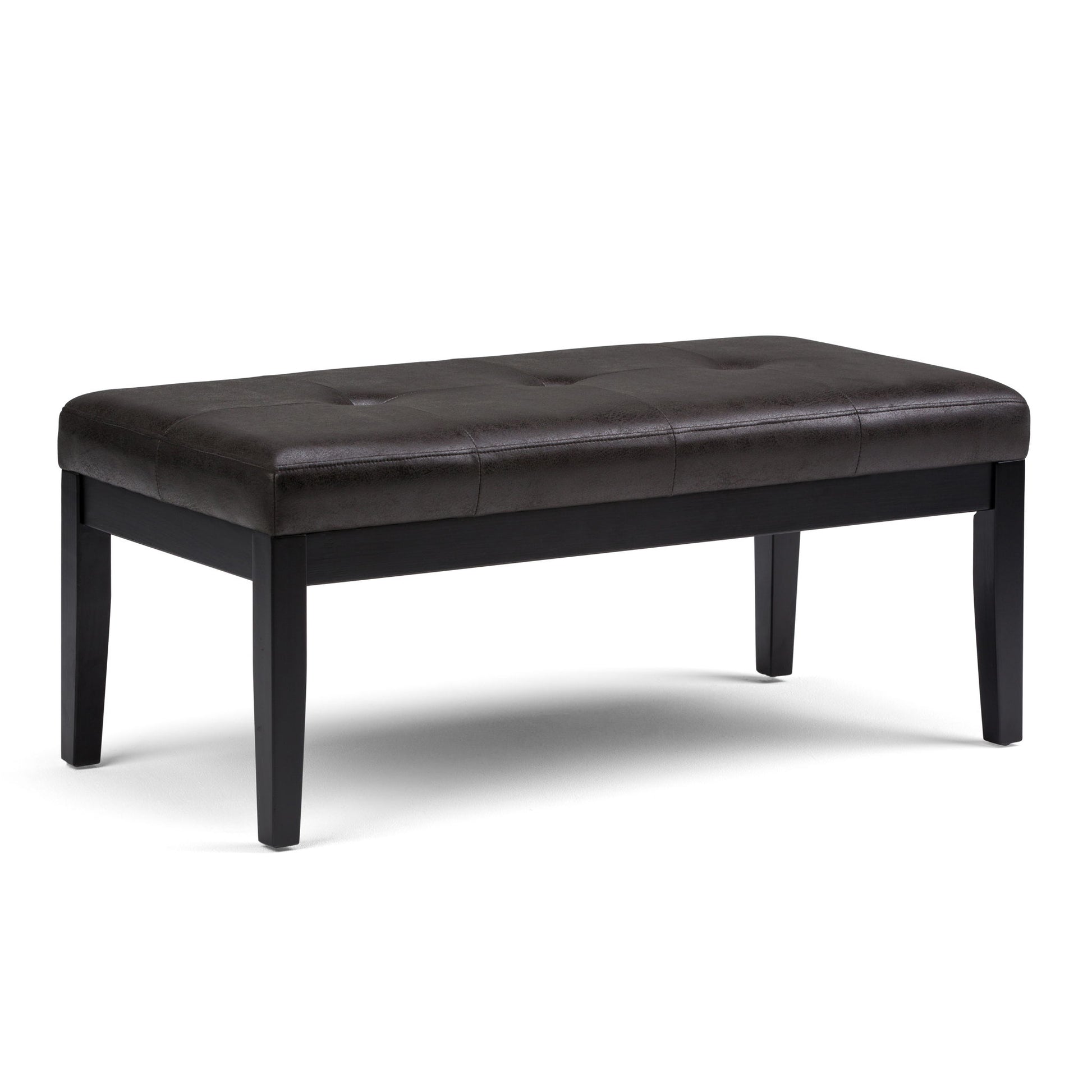 The Lacey - Upholstered Tufted Ottoman Bench features a dark brown, tufted seat and four straight black wooden legs, shown against a white background.