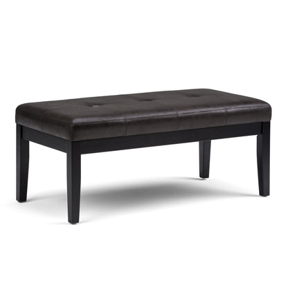The Lacey - Upholstered Tufted Ottoman Bench features a dark brown, tufted seat and four straight black wooden legs, shown against a white background.