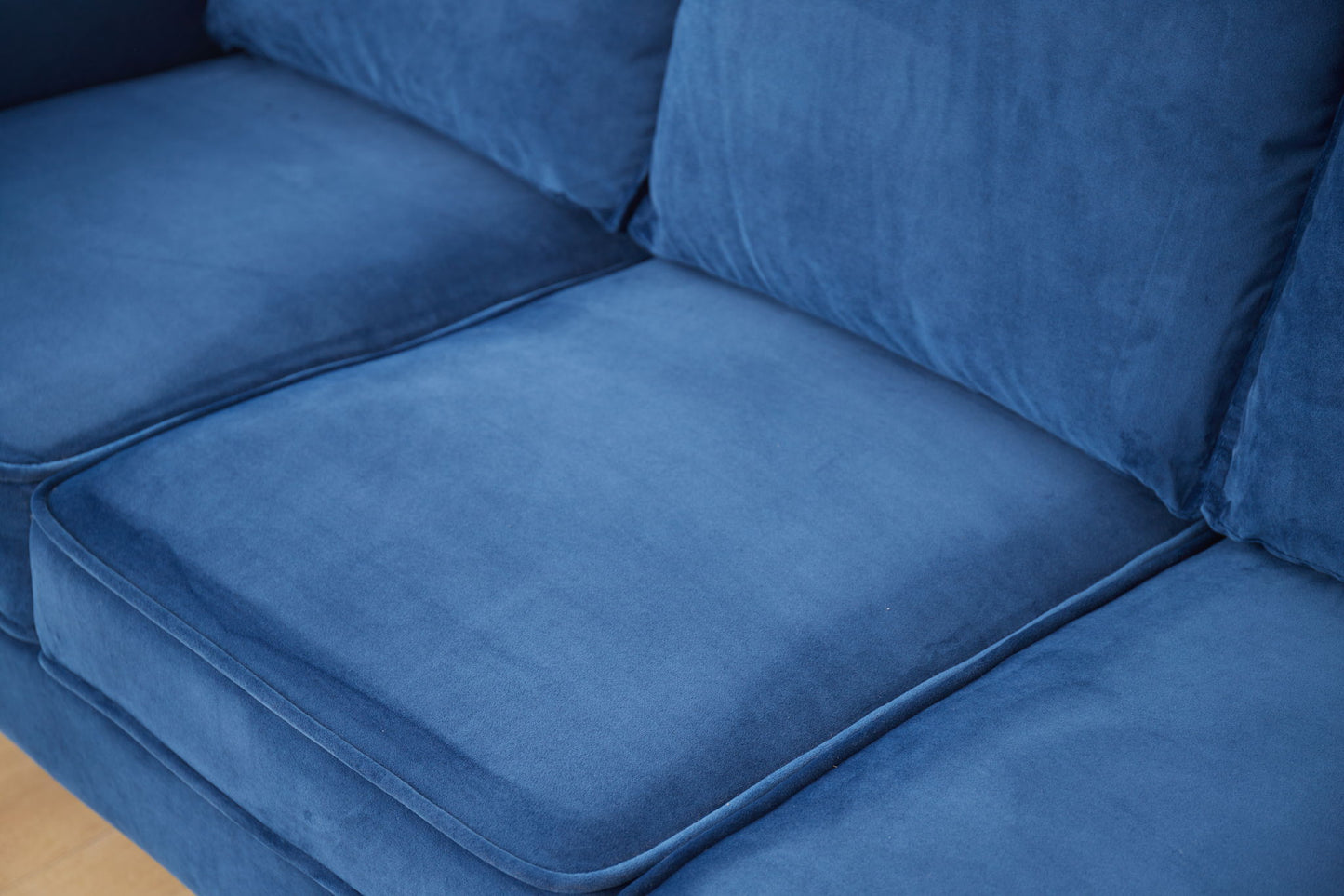 Close-up of the Graceful Design Plush Comfort Sofa in blue velvet, highlighting the smooth, soft seat and back cushions with subtle stitching details.