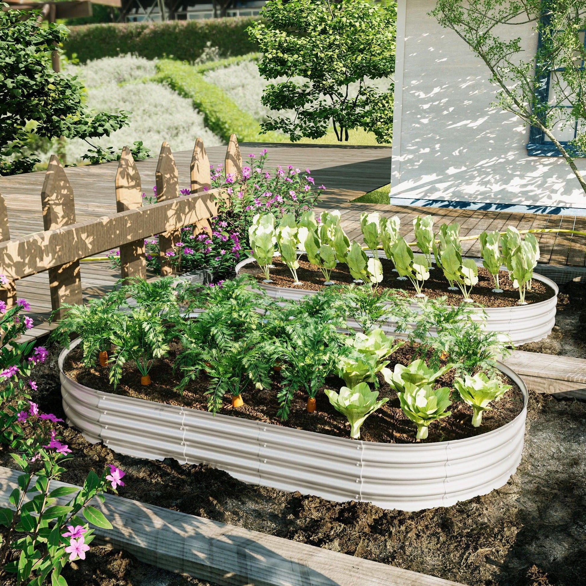 Two Heavy Duty Galvanized Raised Garden Bed Kits for vegetables, flowers, and herbs, filled with greens and carrots, are set in a sunny backyard by a wooden deck, surrounded by flowers and enclosed with a wooden fence.
